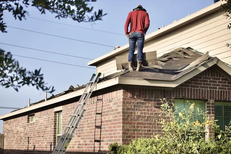 Professional roofer working on a residential roof in West Springfield